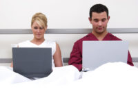 Modern Communication Couple on laptops in bed